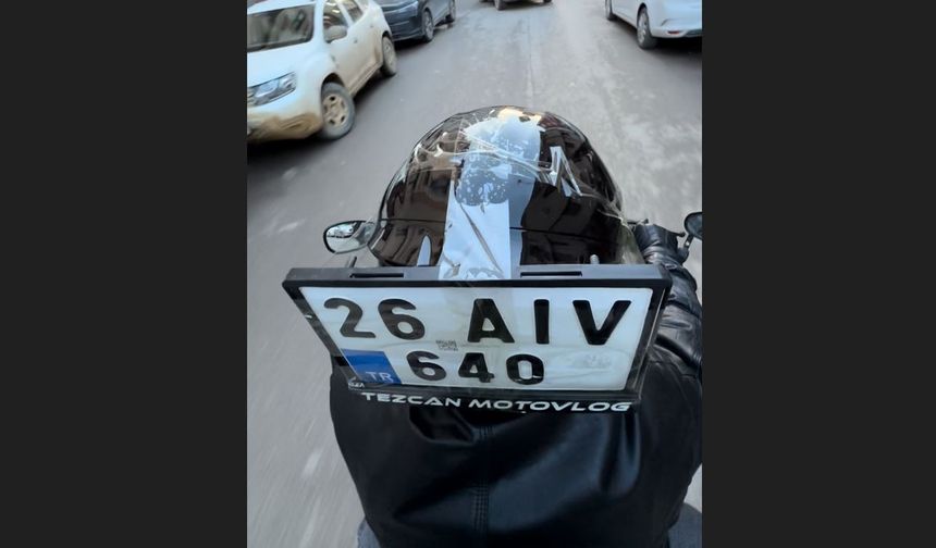 Düşen plakasını kaskına bantlayıp yoluna devam etti